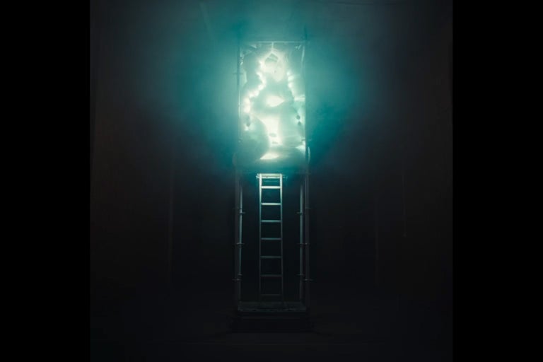 Žebřík před osvětleným objektem ve tvaru včelí plástve