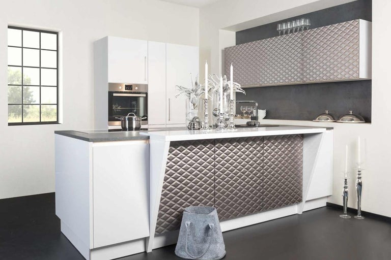 Moderní kuchyně s kuchyňským ostrovem, bílými skříňkami a strukturovanými čely