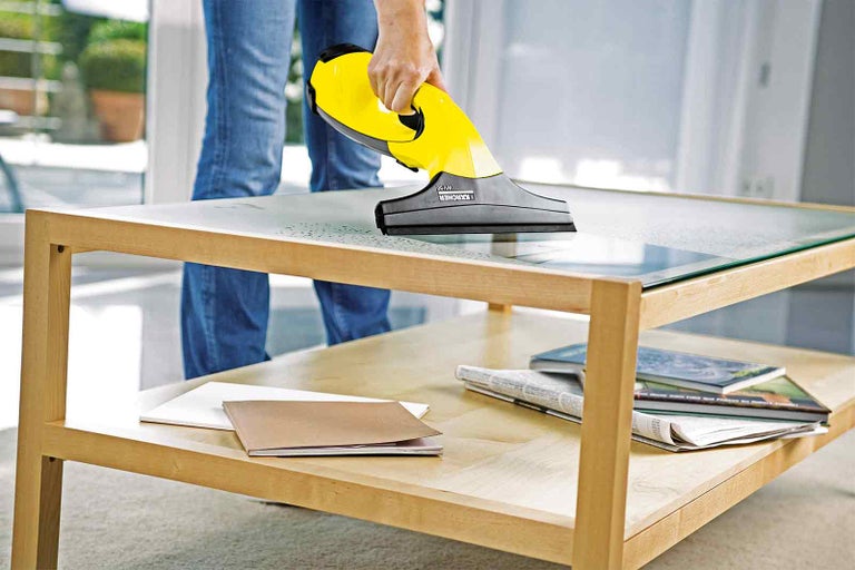 Okenní vysavač se používá na skleněném stole