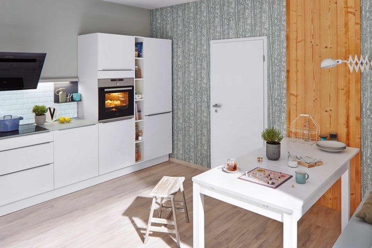 Moderní kuchyně s bílými skříněmi, jídelním stolem a židlí