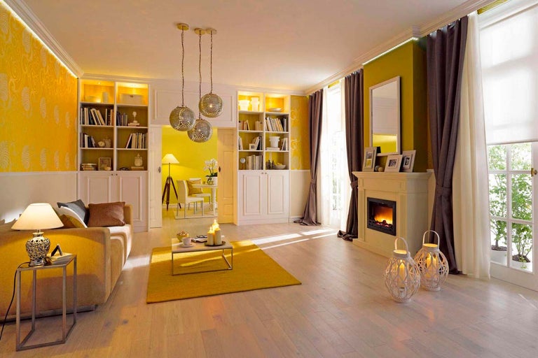 Obývací pokoj s pohovkou, knihovnami, krbem a dekoracemi pro útulnou atmosféru