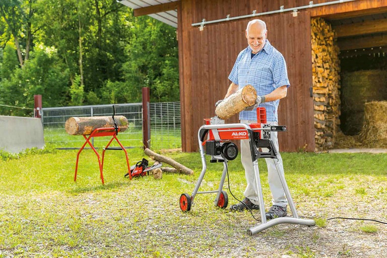 Muž štípe dříví pomocí štípačky na dřevo AL-KO na zahradě.