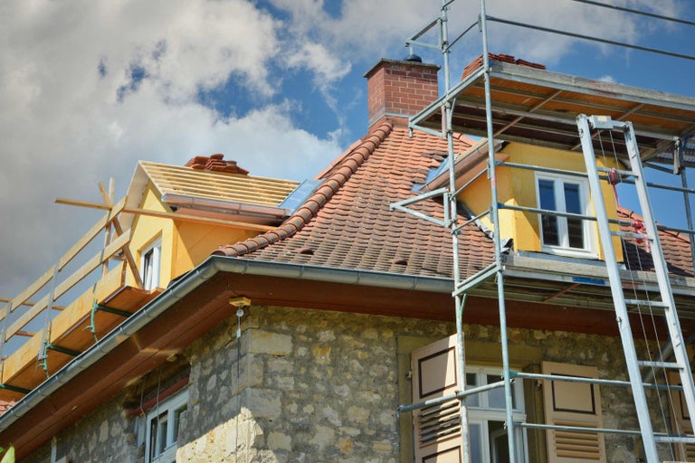Renovace domu s lešením a novou střechou