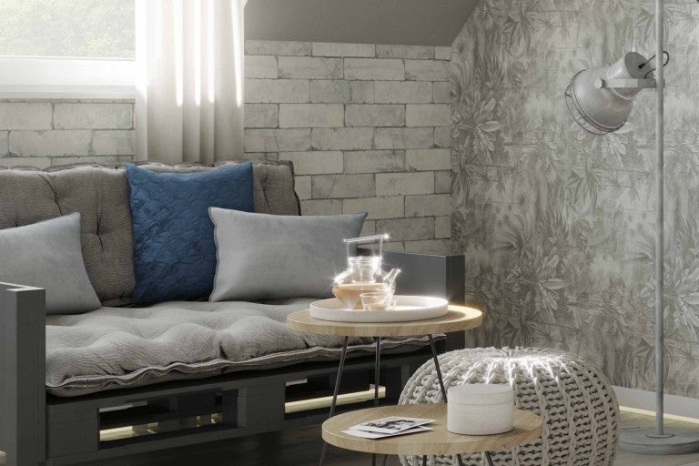 Obývací pokoj s pohovkou z palet, polštáři, odkládacími stolky, stoličkou a stojací lampou