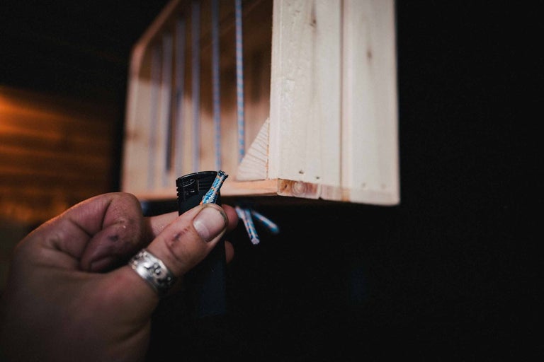 Ruka se zapalovačem a dřevěnou bednou v pozadí