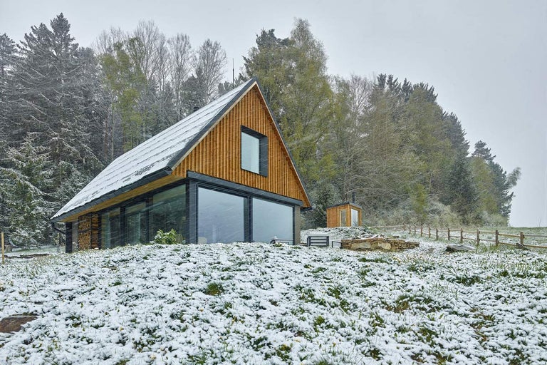 Moderní dřevěný dům s prosklenou fasádou v zimě