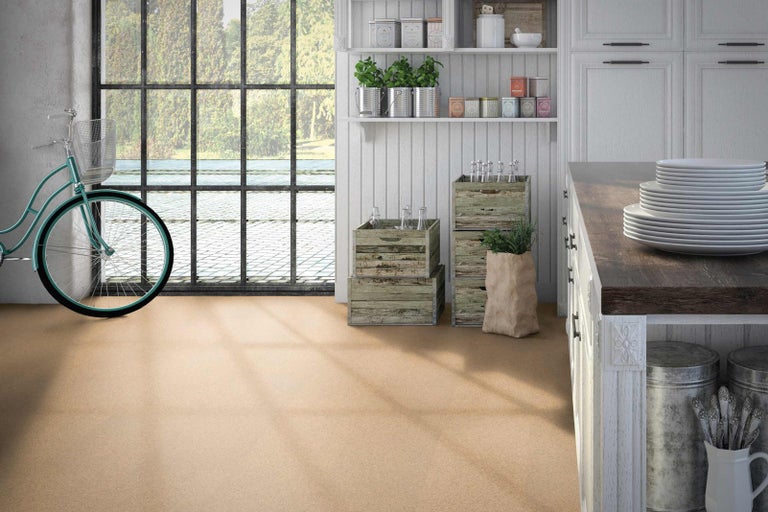 Světlá kuchyně s korkovou podlahou, kolo u okna, police a dřevěné bedny.