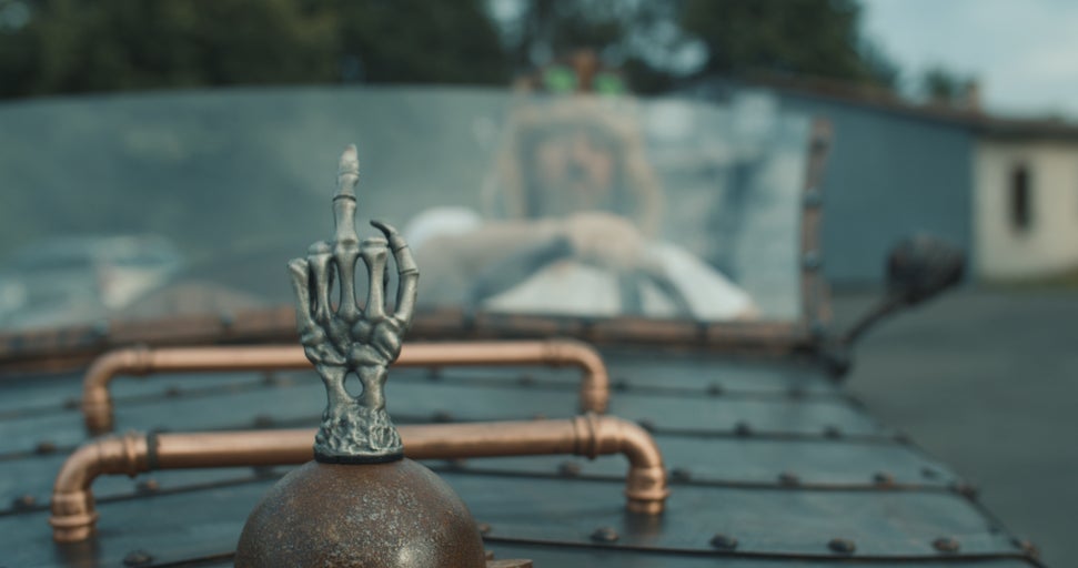 Ozdobné auto s nataženou rukou jako prostředníček