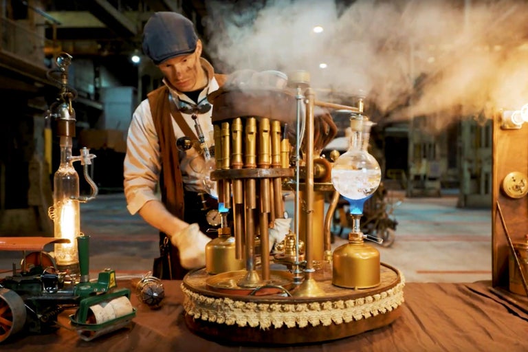 Muž v pracovním oděvu obsluhující parní stroj steampunk