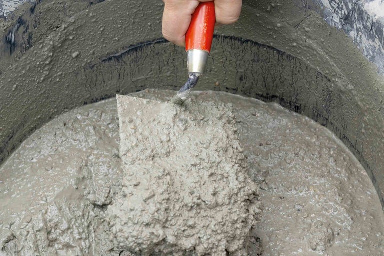 Kbelík s namíchaným betonem a lžící