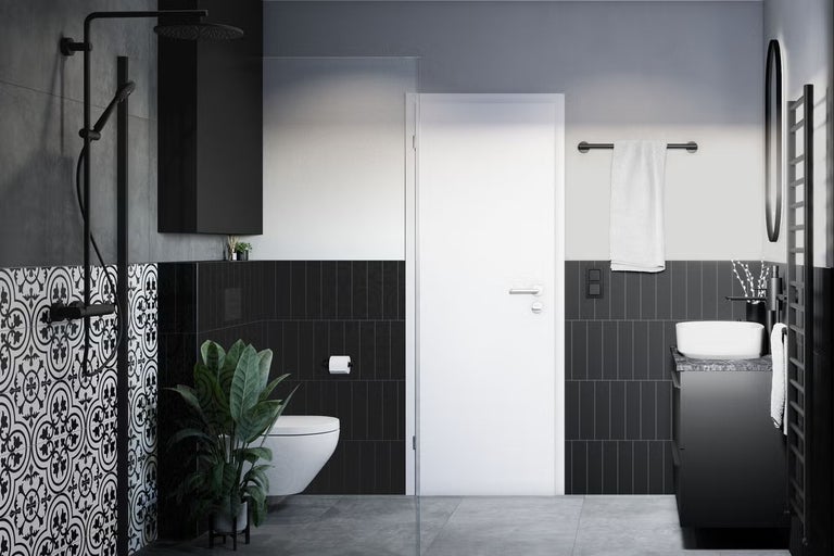 Moderní koupelna se sprchou, umyvadlem, toaletou a černými dlaždicemi