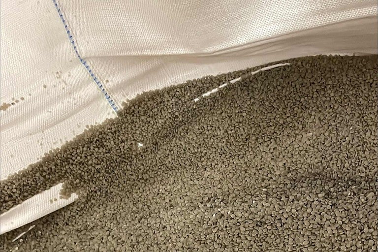 Detailní záběr plastového granulátu v pytli