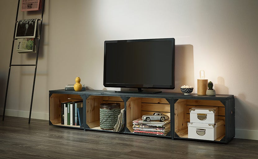 Obývací pokoj s televizí na nízké skříňce z dřevěných beden, žebřík na noviny na zdi