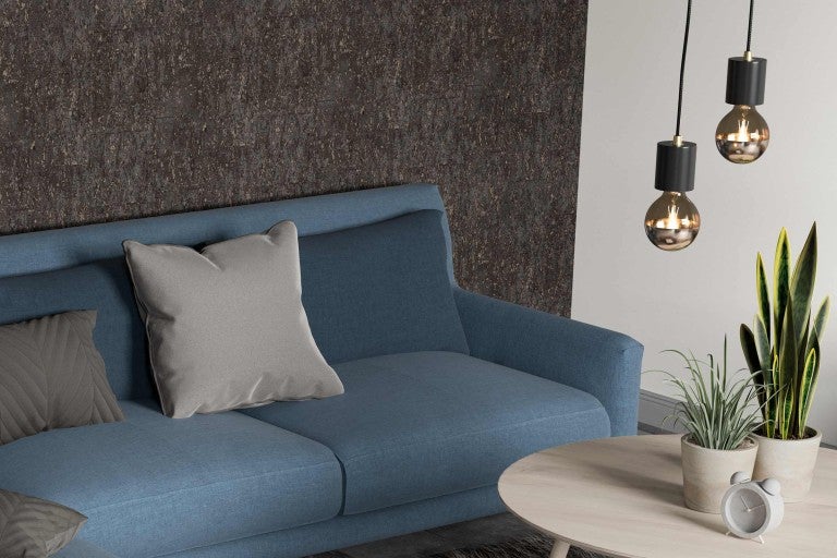 Obývací pokoj s pohovkou, polštáři, konferenčním stolkem, pokojovými rostlinami a závěsnými svítidly.