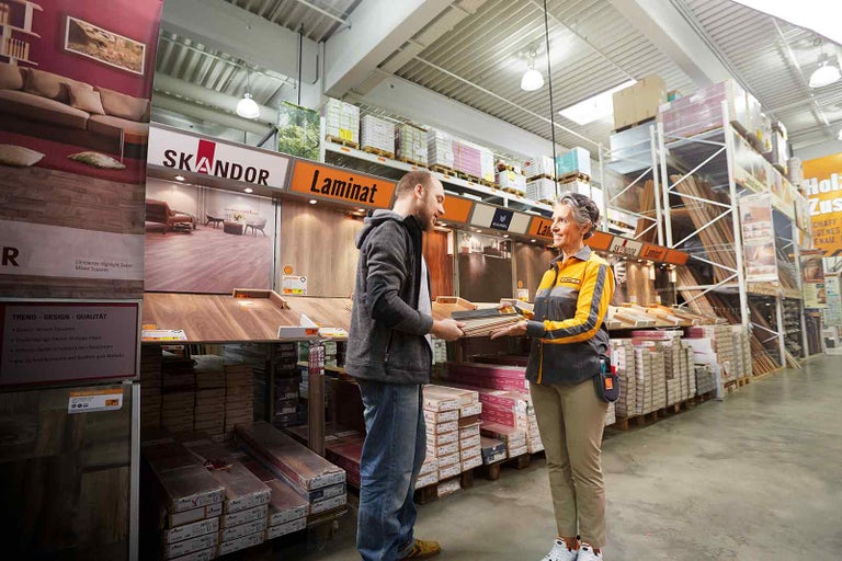Zákazník a zaměstnanec v prodejně Hornbach před výstavou laminátů