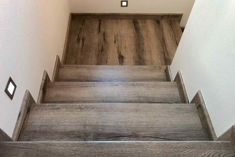 Schodiště s dřevěnými schody a dřevěnými stěnovými panely a osvětlením schodů