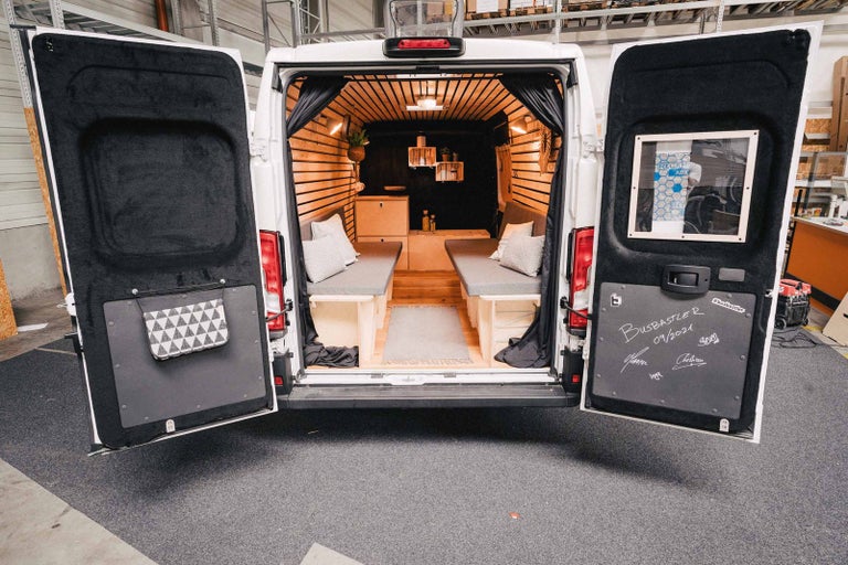 Interiér přestavěné dodávky s dřevěným obložením a postelemi