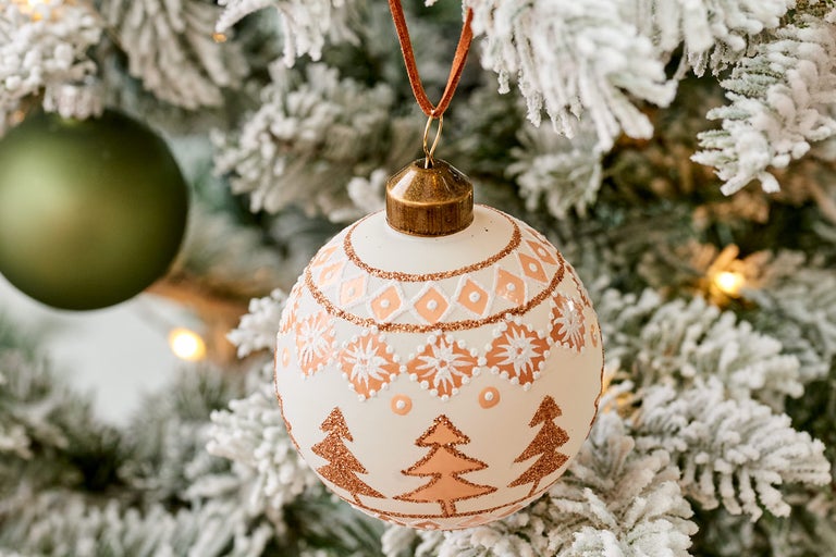 Vánoční baňka s dekorem na ozdobeném stromě