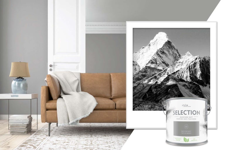 Obývací pokoj s hnědou pohovkou, stolní lampou a plechovkou barvy na stěny