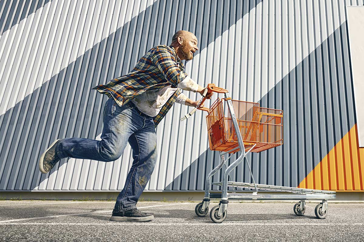 Muž běží s nákupním vozíkem
