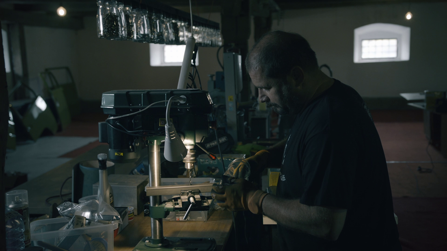 Muž pracuje se sloupovou vrtačkou v dílně