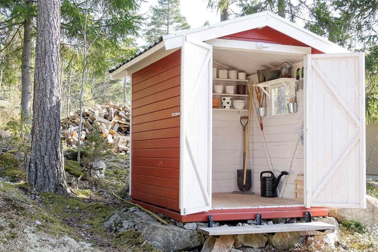 Zahradní kůlna s otevřenými dveřmi, policemi a zahradním nářadím