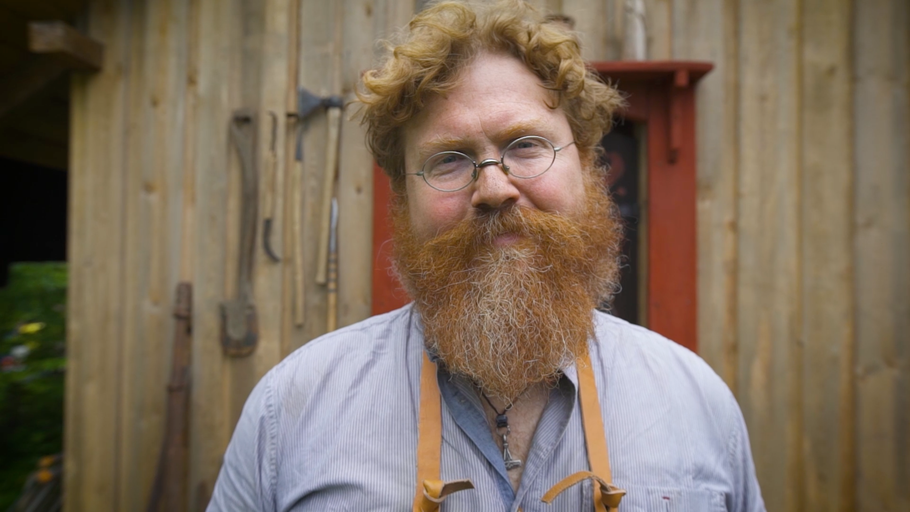 Portrét muže s vousy a nástroji v pozadí