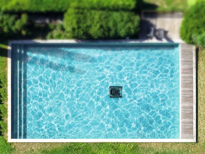 Pohled shora na bazén s bazénovým robotem