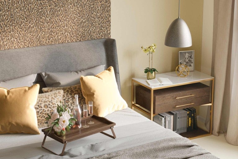 Ložnice s postelí, nočním stolkem a dekoracemi pro útulnou atmosféru