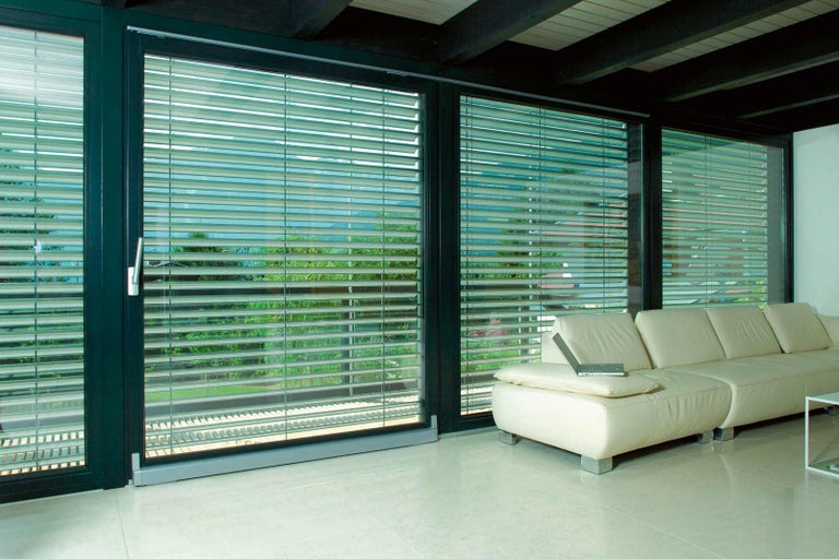 Interiér s okenní stěnou, žaluziemi a pohovkou