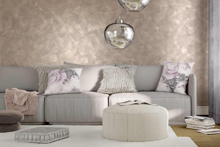 Obývací pokoj s pohovkou, polštáři, stoličkou a dekorativní stěnou.