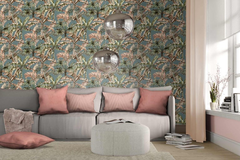Obývací pokoj s pohovkou, polštáři a stěnou s tapetou s motivem palem.