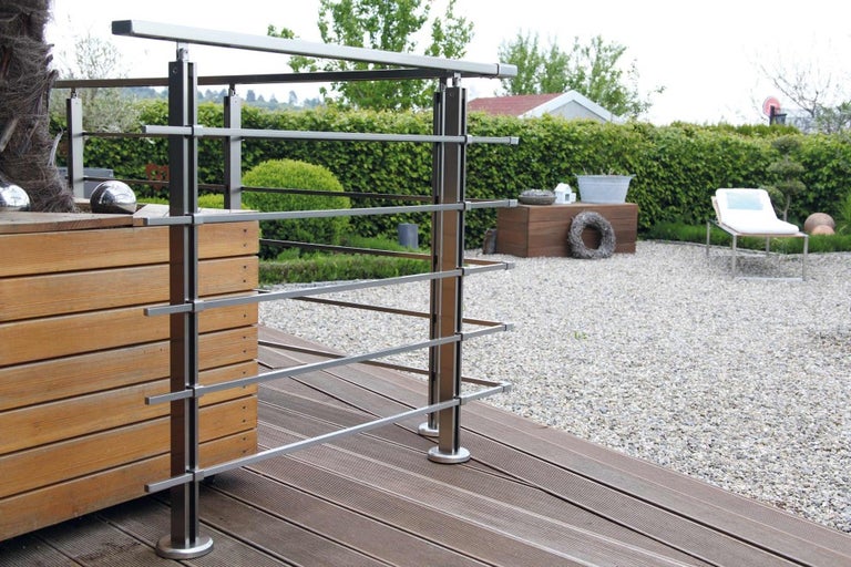 Venkovní fotografie nerezového zábradlí na dřevěné terase se štěrkem na zahradě