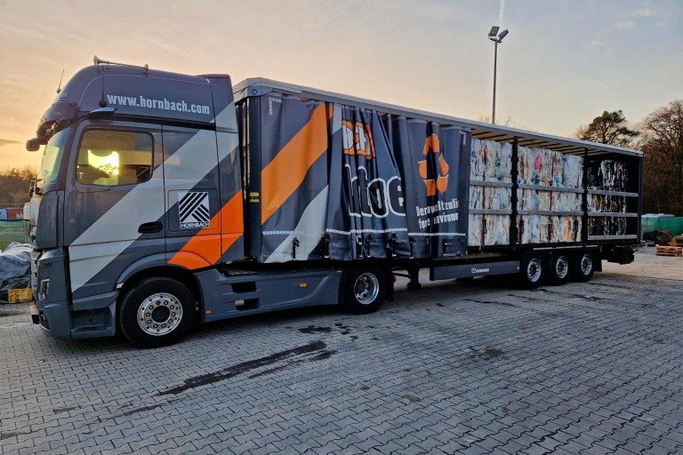Nákladní vůz značky Hornbach naložený recyklačním materiálem.