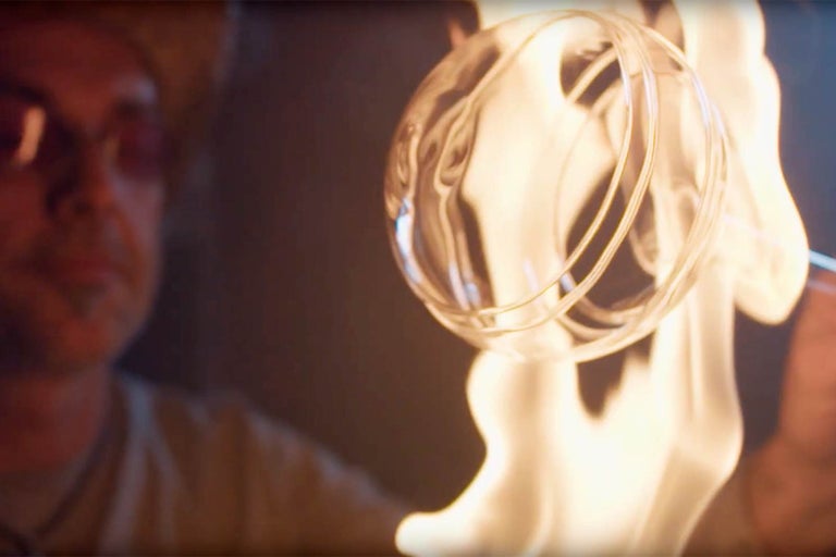 Sklář vyrábí skleněnou květinu