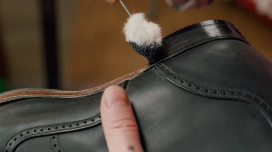 Čištění bot kartáčem na kožené botě