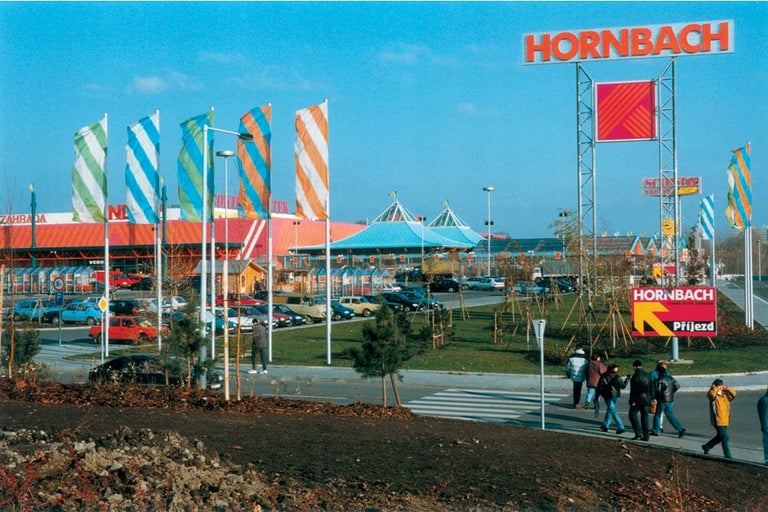 Vnější pohled na pobočku Hornbach s parkovištěm a zákazníky.