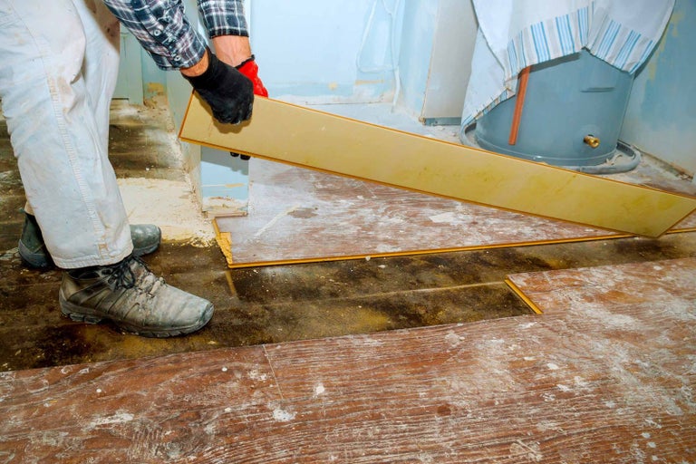 Řemeslník pokládá laminátovou podlahu v místnosti