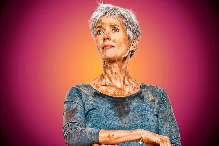 Žena pokrytá hlínou se dívá nahoru