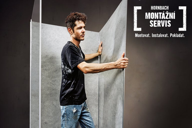Muž montuje obklad stěny s montážním servisem Hornbach.