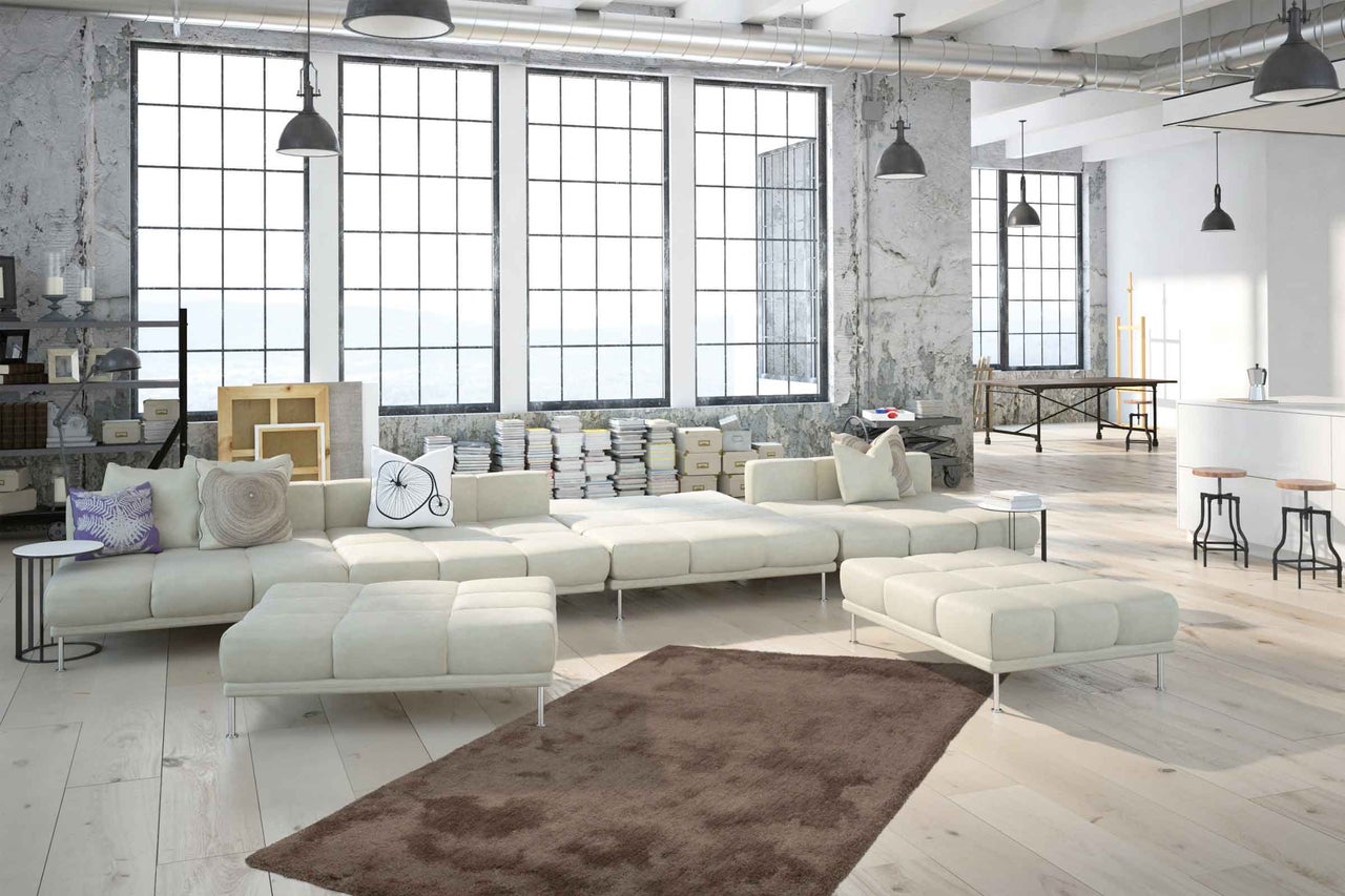 Světlý obývací pokoj s velkým oknem, rohovou pohovkou, kobercem a prvky industriálního designu