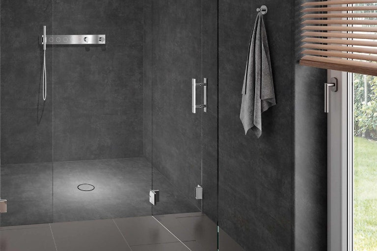 Sprchový kout se skleněnými dveřmi a nerezovým kováním v moderní koupelně.