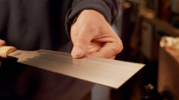 Ruční pila je držena.