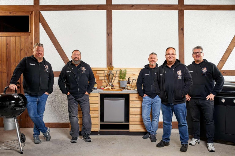 Pět mužů stojí před grilem s grilovacím zařízením a chladničkou na nápoje