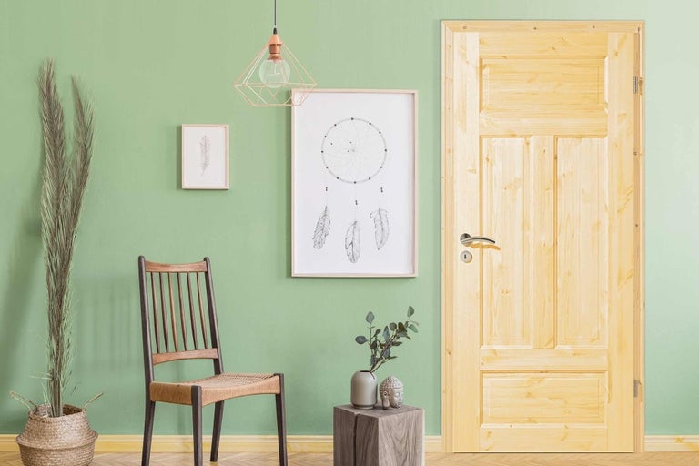 Obývací pokoj s dřevěnými dveřmi, židlí, dekorací a obrazy pro stylové prostředí