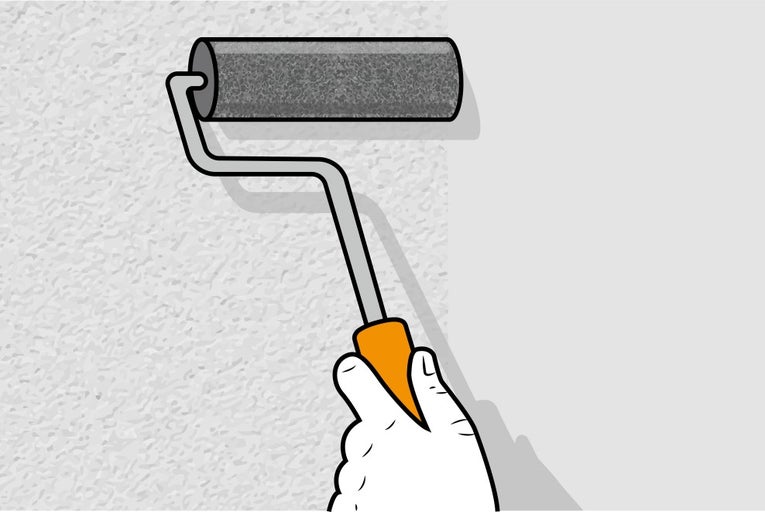 Ruka drží váleček na malování stěny