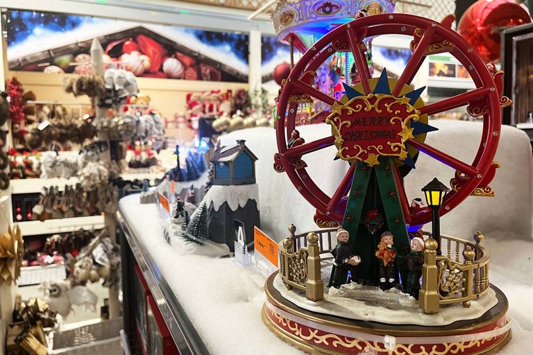 Vánoční dekorace s osvětleným ruským kolem a miniaturními figurkami.