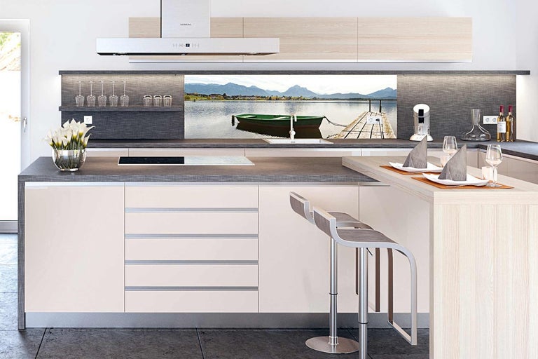 Moderní kuchyně s kuchyňským ostrovem, barovými stoličkami a zadní stěnou s motivem jezera