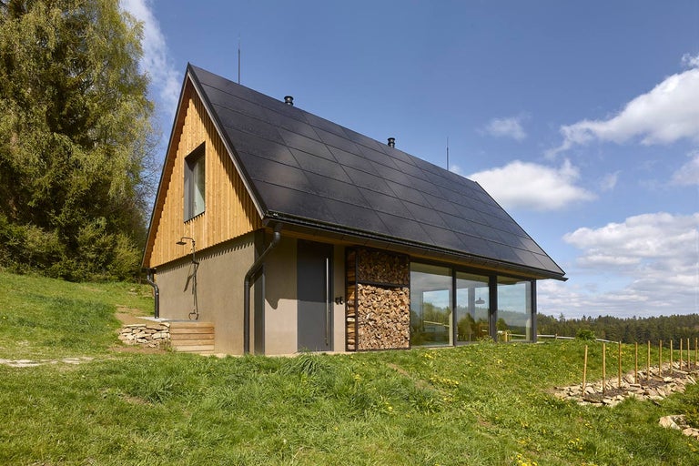 Dům se solárním systémem na střeše a dřevěnou stěnou