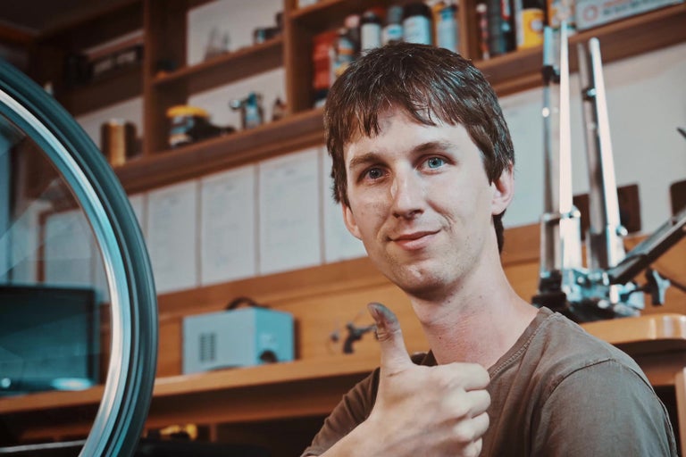 Muž dává palec nahoru v dílně s kolem